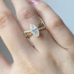A modern twist on a classic, this unique engagement ring features a stunning marquise-cut diamond on a crossover pavé band. - 7