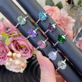 Elegant and colorful, this oval-cut ring features a stunning central stone and a pavé-encrusted split shank band.