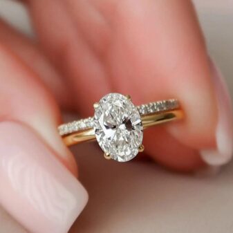 an oval-cut diamond engagement ring with a matching pavé wedding band.