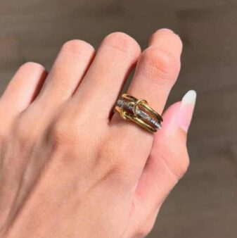 A stylish combination of two gold and one silver-toned ring, showcasing a modern, interlocking design.