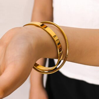 A set of two sleek, polished gold bangles.
